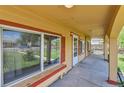 Inviting covered front porch with decorative columns, exterior lighting, and a bench at 6671 Grove St, Denver, CO 80221