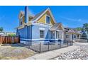 View of the charming two-story blue home showcasing an adjacent gray sidewalk at 523 W 8Th Ave, Denver, CO 80204