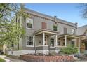 Attractive gray brick home with a covered front porch and a well-maintained brick landscape at 2562 N Emerson St, Denver, CO 80205