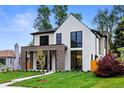 Beautiful home featuring a mix of white siding, brickwork, expansive windows, and a well-manicured lawn at 1126 S Garfield St, Denver, CO 80210