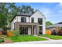 Stylish two-story home with white siding, brick details, dark-framed windows, and green grass at 1126 S Garfield St, Denver, CO 80210
