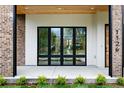 Inviting front porch with brick columns, sleek black window frames, and a modern wood door at 1126 S Garfield St, Denver, CO 80210