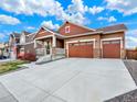 Attractive exterior featuring a well-manicured lawn, a three car garage, and a welcoming front porch at 1297 Black Haw St, Elizabeth, CO 80107