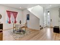 Bright dining area with hardwood floors, a table, and a view of the front entryway at 8984 Eagle River St, Littleton, CO 80125
