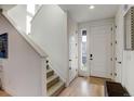 Bright entryway with hardwood floors, a staircase, and a white front door with sidelight window at 8984 Eagle River St, Littleton, CO 80125