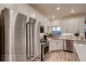 Modern kitchen featuring stainless steel appliances, bright cabinetry, and a view from the kitchen window at 920 W 128Th Pl, Westminster, CO 80234