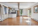 Open-concept living space featuring hardwood floors, stainless appliances, white cabinets and natural light at 5939 S Skyline Dr, Evergreen, CO 80439