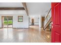 Spacious living room featuring hardwood floors, exposed beam and a fireplace, with natural light from glass doors at 5939 S Skyline Dr, Evergreen, CO 80439