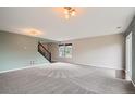 Spacious living room with plush carpet, neutral paint, and ample natural light at 389 Smith Cir, Erie, CO 80516