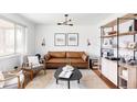 Modern living room featuring a stylish brown leather sofa and neutral decor at 4571 Beach Ct, Denver, CO 80211