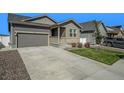 Gray house with a two-car garage, landscaping, and a gravel driveway at 2237 Barela Dr, Berthoud, CO 80513