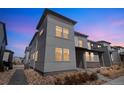 Modern gray two-story home exterior with a low maintenance landscape and a walkway at 19197 E 64Th Ave, Denver, CO 80249