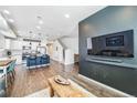 Open-concept living room and kitchen featuring hardwood floors, modern lighting, and stainless steel appliances at 19197 E 64Th Ave, Denver, CO 80249
