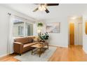 Living room featuring hardwood floors, a brown leather sofa, and a large window at 3326 N Fillmore St, Denver, CO 80205