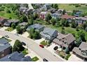 An aerial view of a neighborhood displaying the home's location with tree-lined streets and well-maintained lawns at 7329 Arco Iris Ln, Castle Pines, CO 80108