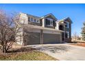 Two-story house with gray siding, stone accents, and a two-car garage at 11729 Elmer Linn Dr, Longmont, CO 80504