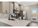 Bright kitchen showcasing quartz countertops, stainless steel appliances, and grey cabinetry at 9462 Yampa Ct, Commerce City, CO 80022