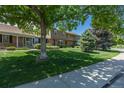 Charming townhome exterior featuring lush green lawns and mature trees in a tranquil neighborhood setting at 8780 E Yale Ave, Denver, CO 80231
