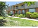 Attractive townhome with a brick exterior, complemented by lush landscaping and a charming second-floor balcony at 8780 E Yale Ave, Denver, CO 80231