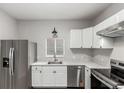 Modern kitchen with stainless steel appliances, white cabinets, and granite countertops at 725 Knox Ct, Denver, CO 80204