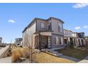 Contemporary two-story home with gray siding, well-manicured lawn, and inviting front porch at 5110 E 64Th Ave, Commerce City, CO 80022