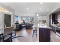 Open-concept living room and kitchen area with modern finishes and abundant natural light at 5110 E 64Th Ave, Commerce City, CO 80022