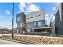 Modern three-story home with a gray brick and white exterior and covered parking at 4911 Lowell Blvd # 102, Denver, CO 80221