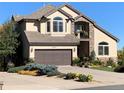 Close-up exterior of a charming home featuring a two-car garage and well-manicured landscaping at 16223 River Haven Way, Morrison, CO 80465