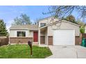 Charming home featuring a brick facade, a red front door, and an attached garage at 17753 E Nassau Pl, Aurora, CO 80013
