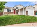 Charming home featuring a brick facade, a red front door, and an attached garage at 17753 E Nassau Pl, Aurora, CO 80013