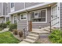 Front exterior of a gray sided townhome with concrete steps and metal railings and minimal front yard landscaping at 6670 W 84Th Cir # 99, Arvada, CO 80003