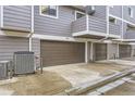 Exterior view of gray siding townhomes with brown garage doors and concrete driveway numbered 99, 98, and 97 at 6670 W 84Th Cir # 99, Arvada, CO 80003