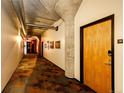 Hallway features exposed pipes, concrete ceiling and modern doors to individual condos at 1863 Wazee St # 4B, Denver, CO 80202