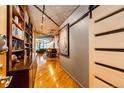 Hallway with hardwood floors, built-in shelving, concrete ceiling and a glimpse into the living area at 1863 Wazee St # 4B, Denver, CO 80202