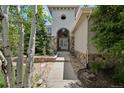 Charming home entrance features a stone facade, arched doorway, and lush greenery at 5665 Vistancia Ct, Parker, CO 80134