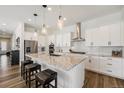 Modern kitchen with white cabinets, granite countertops, stainless steel appliances, and pendant lighting at 7169 Canyon Sky Trl, Castle Pines, CO 80108