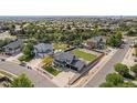 Aerial view of a home with a large backyard, well-manicured lawn, and a three car garage at 504 Branding Iron Ct, Brighton, CO 80601