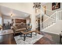 Living room with hardwood floors, elegant stairway, and an open layout leading to the kitchen at 504 Branding Iron Ct, Brighton, CO 80601