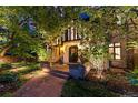 Charming front entrance featuring a brick walkway, stone archway, and lush landscaping at 4600 E 3Rd Ave, Denver, CO 80220