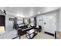 Living room with dark leather couch and dining area at 7020 Avrum Dr, Denver, CO 80221