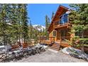 Inviting cabin-style home with a cozy deck, surrounded by lush trees and a mountain view at 563 Brook Dr, Idaho Springs, CO 80452