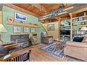 Charming living room boasts a cozy fireplace, wood beams, and rustic decor at 563 Brook Dr, Idaho Springs, CO 80452