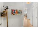 Bright hallway with hardwood floors, coat rack, and decorative artwork at 1438 Little Raven St # 407, Denver, CO 80202