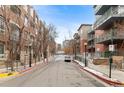 Street view of apartment buildings on either side of a paved road at 1438 Little Raven St # 407, Denver, CO 80202