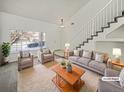 Spacious living room with a staircase, two armchairs, and a sofa at 18986 E 51St Pl, Denver, CO 80249