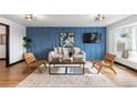 Stylish living room with a blue accent wall, modern furniture, and large windows at 6764 Hillridge Pl, Parker, CO 80134