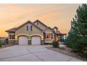 Attractive home exterior with stone accents, mature landscaping, and two-car garage at 15947 Bridle Ridge Dr, Monument, CO 80132