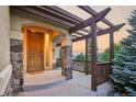 Charming covered porch with stone columns, wood beams, and scenic views at 15947 Bridle Ridge Dr, Monument, CO 80132