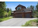 Charming exterior of two-story home with a two-car garage and lovely landscaping on a sunny day at 5 Ronnie Rd, Golden, CO 80403