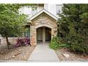 Close-up of the stone archway entrance with unit numbers and decorative landscaping at 10010 E Gunnison Pl # 707, Aurora, CO 80247